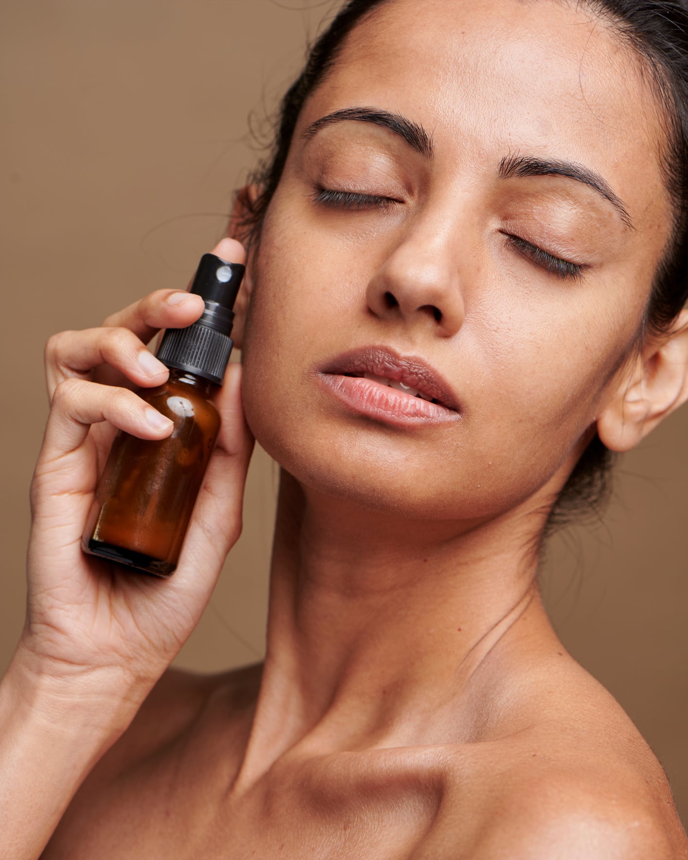 Woman Holding Bottle of Skincare Product